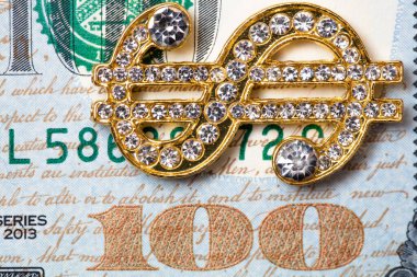 golden dollar sign with gemstones on 100 dollar banknote background for design purpose