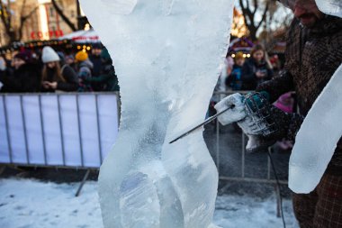 Lviv, Ukrayna - 15 Ocak 2022: Dnipro elektrikli testereyle buz heykeli yapan adam