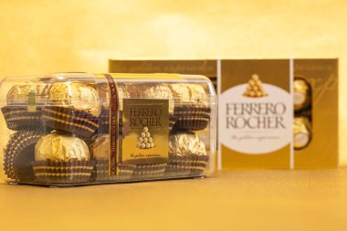 İtalya - 27 Ocak 2022: Altın parıltılı arka planda izole edilmiş Ferrero Rocher premium çikolatası