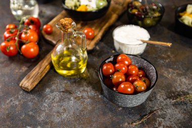 Kiraz domatesleri, bir kase salata, tasarım amaçlı yağlı sürahi.