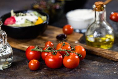 Kiraz domatesleri, bir kase salata, tasarım amaçlı yağlı sürahi.