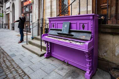 Lviv, Ukraine - March 16, 2022: Purple piano on Lviv street clipart