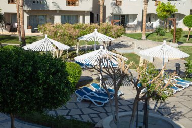 Hurghada, Mısır - 1 Ekim 2019: Mısır 'ın başkenti Hurghada' daki Jaz Casa Del Mar Resort 'ta güneşlik şemsiyeler ve güneşlik yatakları