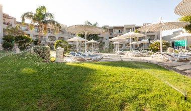 Hurghada, Mısır - 1 Ekim 2019: Mısır 'ın başkenti Hurghada' daki Jaz Casa Del Mar Resort 'ta güneşlik şemsiyeler ve güneşlik yatakları