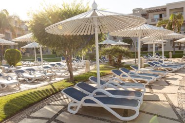 Hurghada, Mısır - 1 Ekim 2019: Mısır 'ın başkenti Hurghada' daki Jaz Casa Del Mar Resort 'ta güneşlik şemsiyeler ve güneşlik yatakları