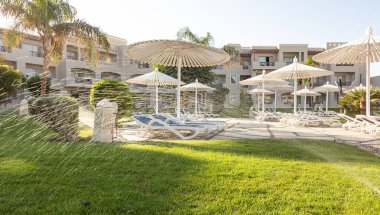 Hurghada, Mısır - 1 Ekim 2019: Mısır 'ın başkenti Hurghada' daki Jaz Casa Del Mar Resort 'ta güneşlik şemsiyeler ve güneşlik yatakları