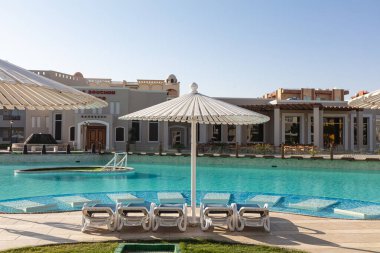 Hurghada, Mısır - 1 Ekim 2019: Mısır 'ın başkenti Hurghada' daki Jaz Casa Del Mar Resort 'ta güneşlik şemsiyeler ve güneşlik yatakları