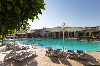 Hurghada, Mısır - 1 Ekim 2019: Mısır 'ın başkenti Hurghada' daki Jaz Casa Del Mar Resort 'ta güneşlik şemsiyeler ve güneşlik yatakları