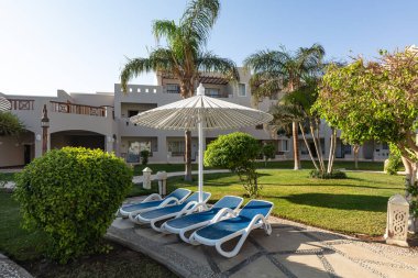 Hurghada, Mısır - 1 Ekim 2019: Mısır 'ın başkenti Hurghada' daki Jaz Casa Del Mar Resort 'ta güneşlik şemsiyeler ve güneşlik yatakları