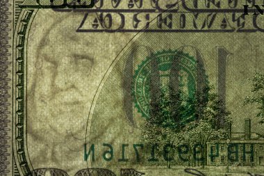 100 dolarlık banknotun bir parçası. Tasarım amacı için banknotun görünür detayları ters çevrilmiş.
