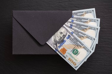 Siyah arka planda el yapımı zarfla 100 dolarlık banknot.