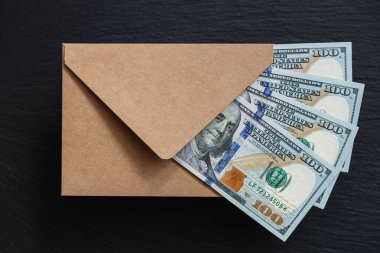 Siyah arka planda el yapımı zarfla 100 dolarlık banknot.