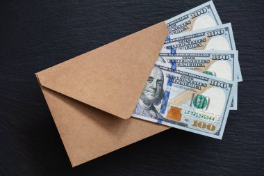 Siyah arka planda el yapımı zarfla 100 dolarlık banknot.