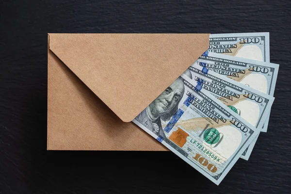 Siyah arka planda el yapımı zarfla 100 dolarlık banknot.