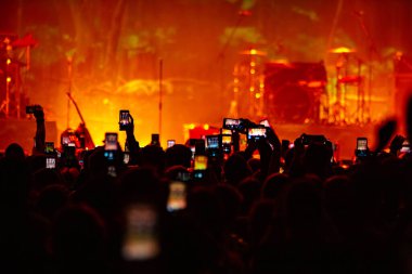 Konserde telefonlu eller, konserde atmosfer, sahne ışıkları