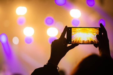 Konserde telefonlu eller, konserde atmosfer, sahne ışıkları