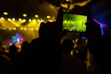 Konserde telefonlu eller, konserde atmosfer, sahne ışıkları