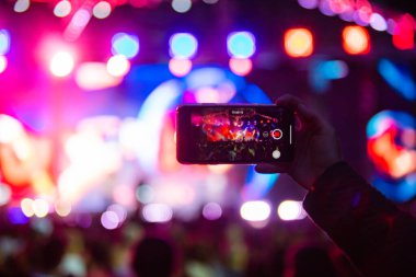 Konserde telefonlu eller, konserde atmosfer, sahne ışıkları