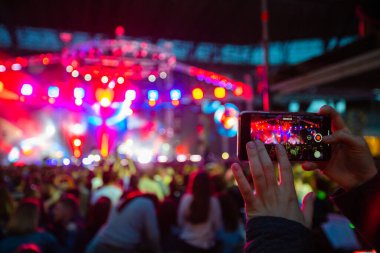 Konserde telefonlu eller, konserde atmosfer, sahne ışıkları