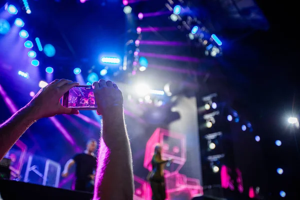 Hands with phones on concert, atmosphere on concert, stage lights