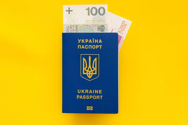 ウクライナのパスポートと黄色の背景にある100枚のゾルティ紙幣 — ストック写真