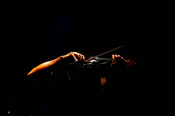 男人在舞台上拉小提琴 手在黑暗的背景上拉小提琴 — 图库照片