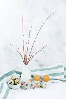 Yumuşak söğüt dallarından bir buket, Paskalya yumurtaları ve arka planda tavşan figürleri. Mutlu Paskalyalar, Palm Sunday. Minimalizm tarzında Paskalya kompozisyonu. Paskalya kartı.