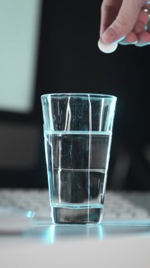 Tablet bir bardak suya düşer. Alevli tablet aspirin. Çalışma alanı arkaplanına yakın plan