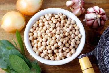 Kaba içinde çiğ organik nohut taneleri kırsal ahşap masa üzerinde. Üst görünüm