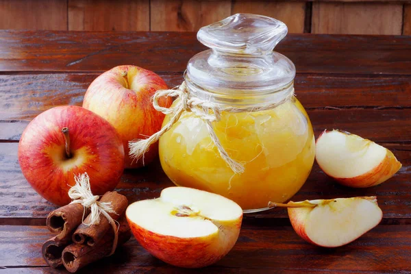 homemade apple sauce or apple puree in glass bowl over rustic wooden table. top view