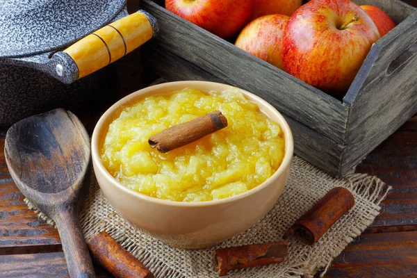 homemade apple sauce or apple puree in ceramic bowl over rustic wooden table. top view