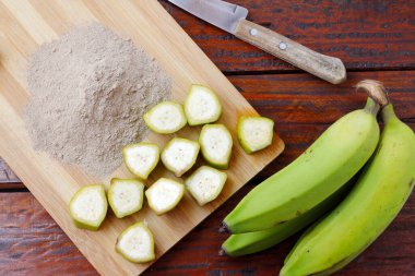 Organik yeşil muz unu, ezilmiş, çiğ ve kuru ahşap kasede. Glütensiz un. en üstteki görünüm