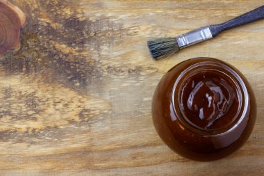 Kasede barbekü sosu ve kırsal ahşap masada fırça. Baharatlar ve bitkiler