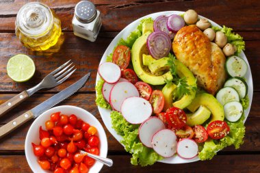 Ketogenik ya da paleo diyet tabağı, ızgara tavuk göğsü ve ahşap masa üzerinde avokado. Az karbonhidrat, sağlıklı beslenme. en üstteki görünüm