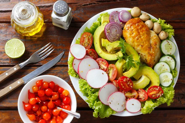 Ketogenik ya da paleo diyet tabağı, ızgara tavuk göğsü ve ahşap masa üzerinde avokado. Az karbonhidrat, sağlıklı beslenme. en üstteki görünüm