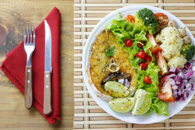 Sağlıklı ızgara balık ve sebze salatasını kırsal ahşap masa üzerinde yemek. Ketogenik ve Paleolitik Diyet. en üstteki görünüm