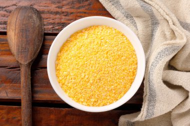Çiğ mısır unu polentada kullanılır, seramik kasede kırsal ahşap masa üzerinde. en üstteki görünüm