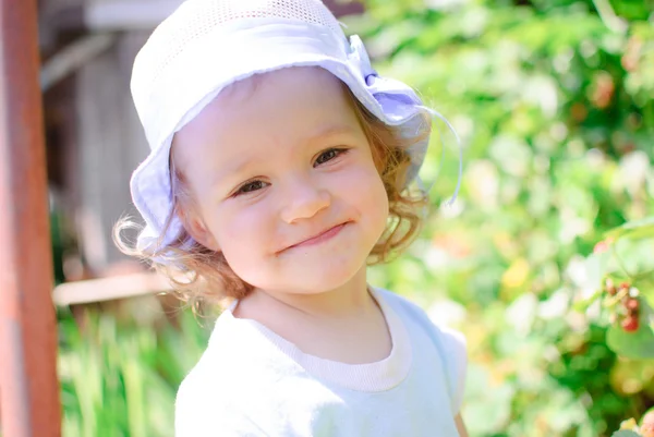 The child eats berries in a garden — Stock Photo, Image