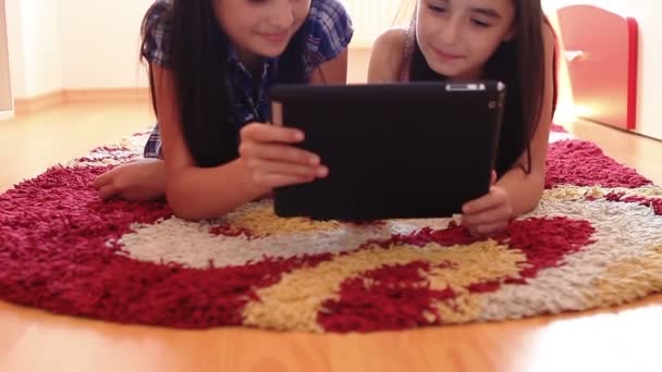 Дві щасливі дівчата-підлітки використовують планшетний комп'ютер — стокове відео