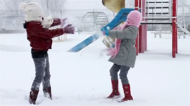 Mädchen kämpfen im Park mit Schnee — Stockvideo