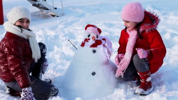 Счастливые девушки со снеговиком — стоковое видео