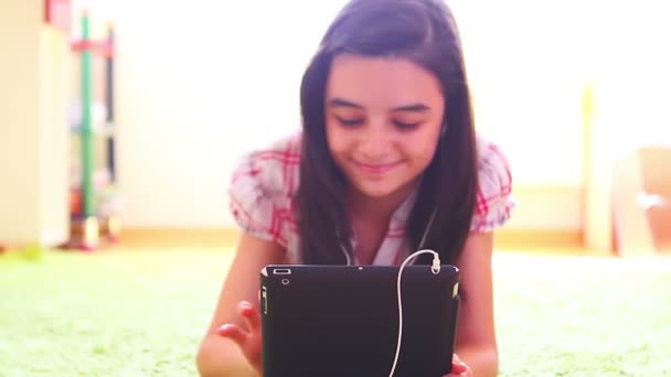 Chica sonriente escuchando música en la tableta digital PC — Vídeo de stock