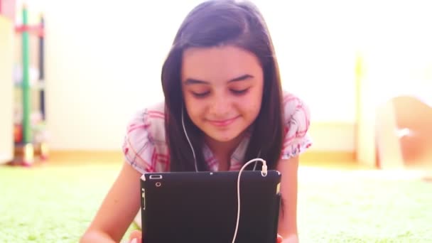 Усміхнена дівчина слухає музику на цифровому планшетному ПК — стокове відео