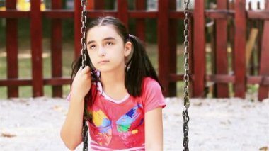 genç kız üzgün salıncağa oturur