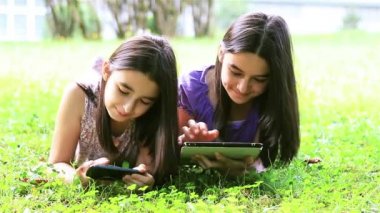 Dijital tablet ve smartphone üzerinde oynayan kızlar