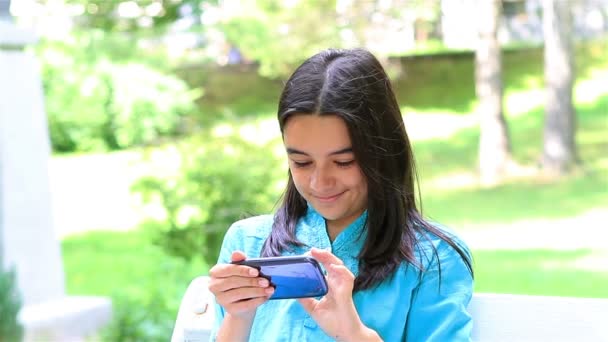 dospívající dívka hrající na smartphonu