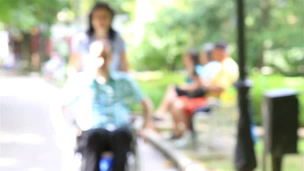 Jonge man in de rolstoel in het stadspark — Stockvideo
