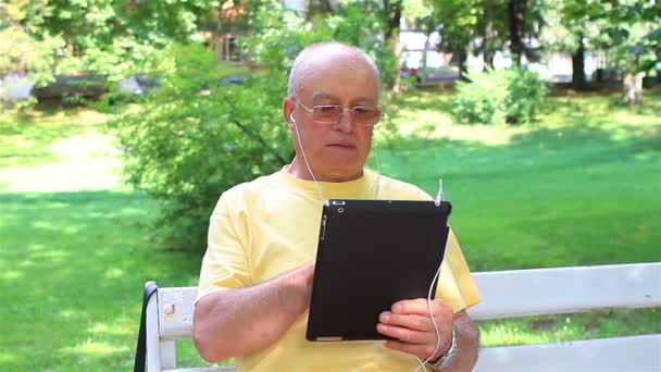 Senior man enjoying music on his digital tablet pc — Stock Video