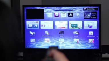 Akıllı tv apps ve genç kadın el uzaktan kumanda tuşuna basarak
