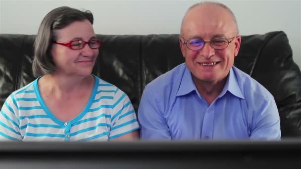 Feliz pareja de ancianos viendo la televisión juntos — Vídeos de Stock